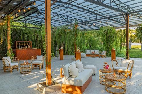 a pavilion with a couch and chairs and a table at W Punta de Mita in Punta Mita