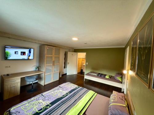 a bedroom with a bed and a tv on the wall at Europa Pension zum Grünen Baum in Rust