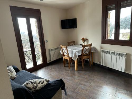 a living room with a table and a couch at Hotel Rural L'Ortiga Blanca in Queralbs