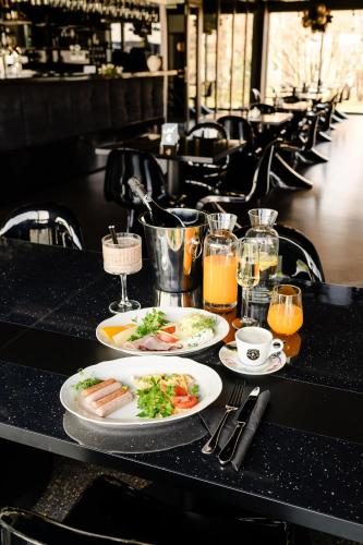 a table with plates of food and glasses of orange juice at Golden Lion House Bed&Breakfast in Rumia