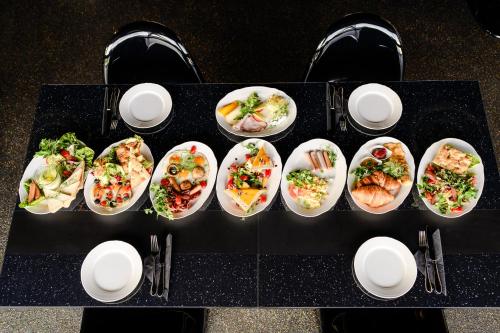 a table with several dishes of food on it at Golden Lion House Bed&Breakfast in Rumia