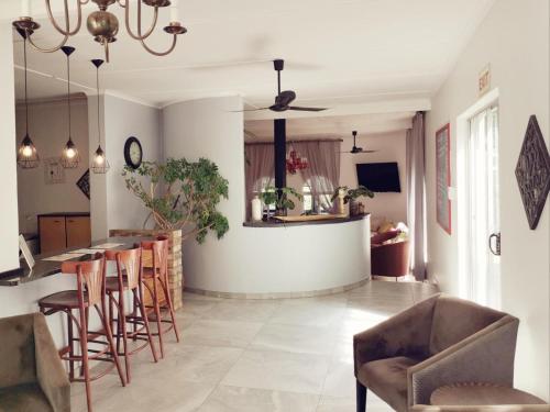 a kitchen and living room with a bar and chairs at Guesthouse Terra Africa in Windhoek