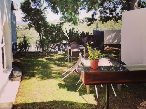 a yard with chairs and a table with a piano at Guesthouse Terra Africa in Windhoek