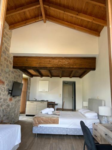 two beds in a room with wooden ceilings at Koukouri Suites in Areopolis