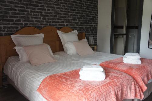 a bedroom with two beds with towels on them at Logis Hôtel Auberge de Cartassac in Sarrazac