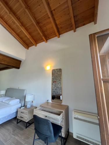 a bedroom with a bed and a desk with a mirror at Koukouri Suites in Areopolis