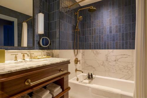 a bathroom with a tub and a sink at Dearborn Inn, Autograph Collection in Dearborn
