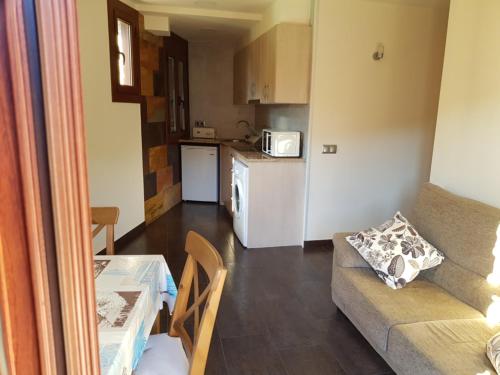 a small living room with a couch and a kitchen at Hotel Rural L'Ortiga Blanca in Queralbs