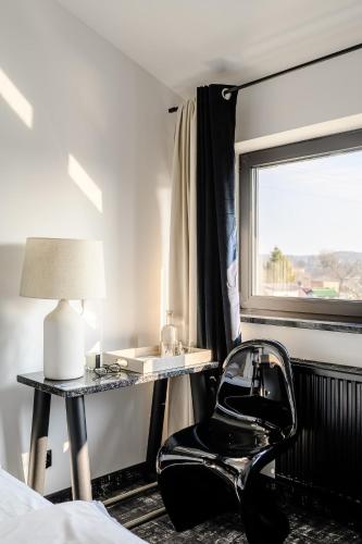 a black chair in a bedroom with a window at Golden Lion House Bed&Breakfast in Rumia