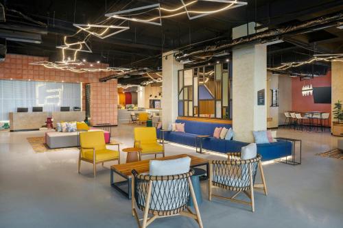 a room with colorful chairs and a table and chairs at Aloft Cancun in Cancún