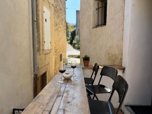 two glasses of wine sitting on a wooden table at Maison cosy en Provence Proche Golf Pont Royal in Alleins