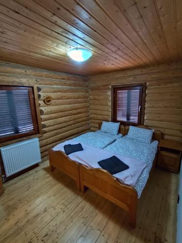a bedroom with a bed in a wooden cabin at Veresko Villa in Lacu Rosu