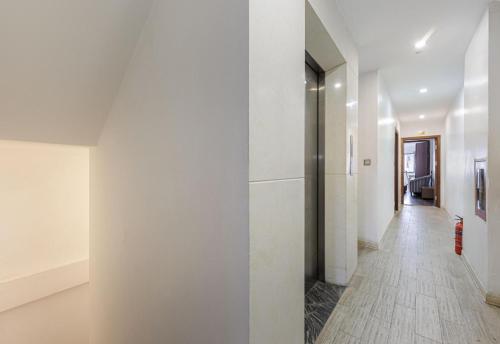 a hallway with white walls and a white floor at Collection O Le Grand Hanoi hotel - The Tryst in Hanoi