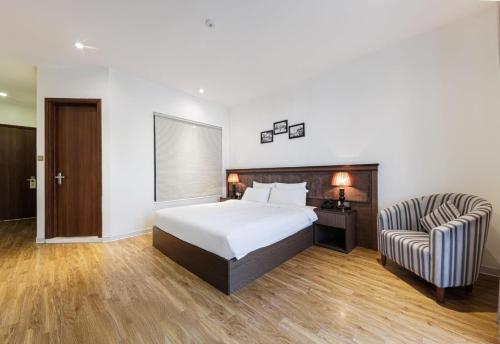 a hotel room with a bed and a chair at Collection O Le Grand Hanoi hotel - The Tryst in Hanoi