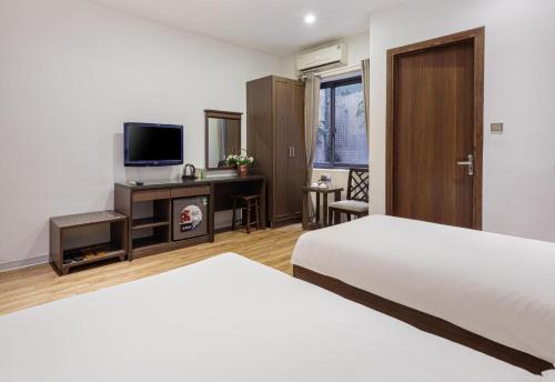 a hotel room with two beds and a television at Collection O Le Grand Hanoi hotel - The Tryst in Hanoi