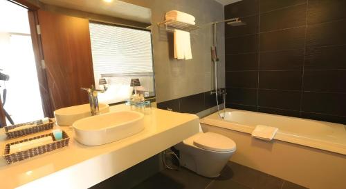 a bathroom with a sink and a toilet and a tub at Collection O Le Grand Hanoi hotel - The Tryst in Hanoi