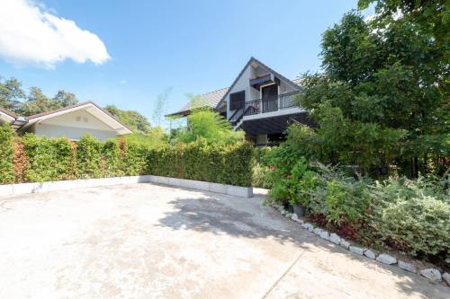 a house with a garden and a driveway at Capital O 75378 Thawapee Resort in Rayong