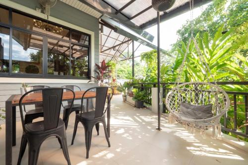 a table and chairs on a patio with plants at Capital O 75378 Thawapee Resort in Rayong