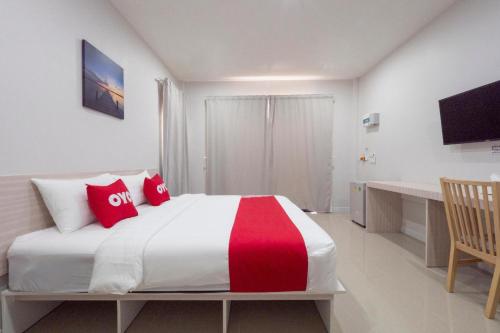 a bedroom with a large bed with red pillows at Capital O 75378 Thawapee Resort in Rayong