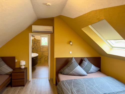 a bedroom with yellow walls and a bed with pillows at Europa Pension zum Grünen Baum in Rust