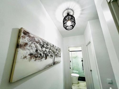 a hallway with a painting on the wall and a chandelier at Domus Citrus in Merida