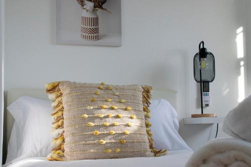 a pillow sitting on top of a white bed at Domus Citrus in Merida