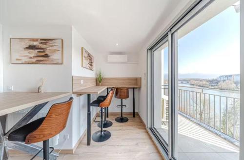 Cette chambre dispose d'un bureau, de chaises et d'un balcon. dans l'établissement Rooftop d'exception, vue Rhône, 12 personnes, Caluire, à Caluire-et-Cuire