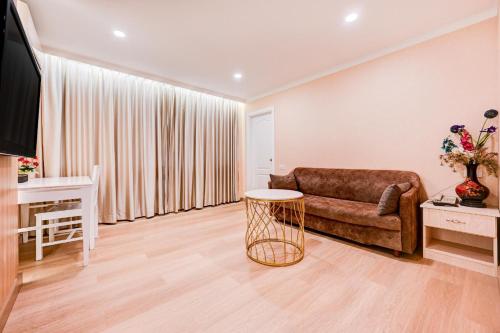 a living room with a couch and a table at Palette The Travellers Hotel Bangkok in Bangkok