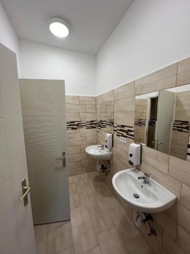 a bathroom with two sinks and two mirrors at Hód-Thermal Camping in Hódmezővásárhely