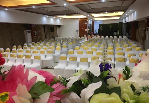 an empty room with white chairs and flowers at Palette The Travellers Hotel Bangkok in Bangkok
