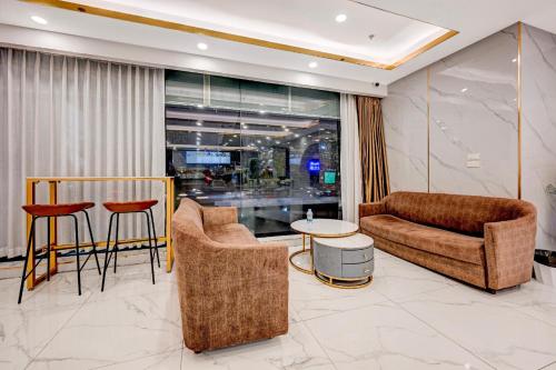 a living room with a couch and chairs and a table at Palette The Travellers Hotel Bangkok in Bangkok