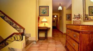 a hallway with a staircase and a desk in a house at Hotel Rural Valle San Emiliano in San Emiliano