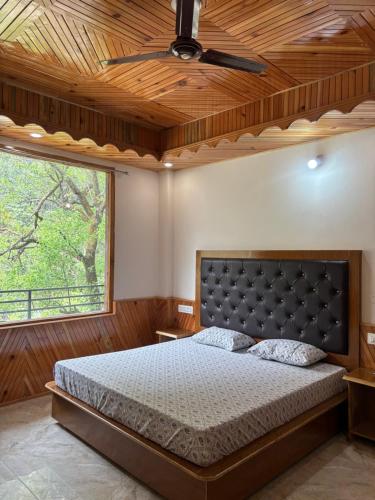 a bedroom with a bed and a ceiling fan at Pine view kasol in Kasol