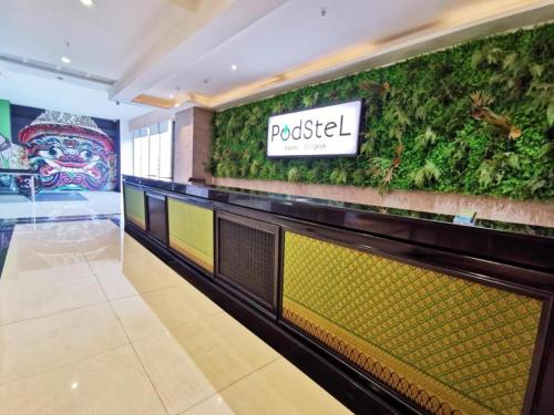 a restaurant with a green wall in a store at Capital O 75451 Podstel Hostel Bangkok in Bangkok