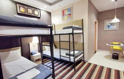 a room with two bunk beds and a table at Capital O 75451 Podstel Hostel Bangkok in Bangkok