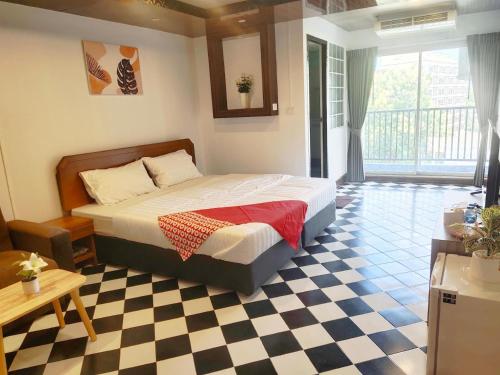 a bedroom with a bed and a checkered floor at OYO 75446 Travis Inthamara 49 in Bangkok