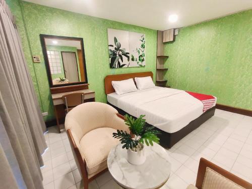 a bedroom with a bed and a table and chairs at OYO 75446 Travis Inthamara 49 in Bangkok