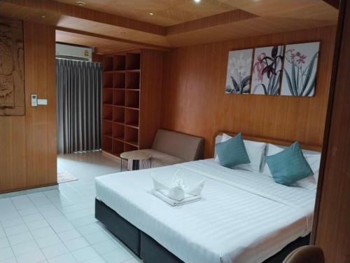 a bedroom with a large white bed with blue pillows at OYO 75446 Travis Inthamara 49 in Bangkok