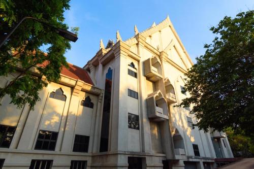 a large white building with a blue sky in the background at Grandview Condominia in Bangkok