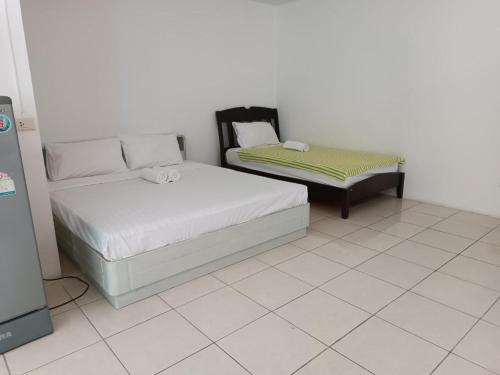 a bedroom with two beds and a couch at Grandview Condominia in Bangkok