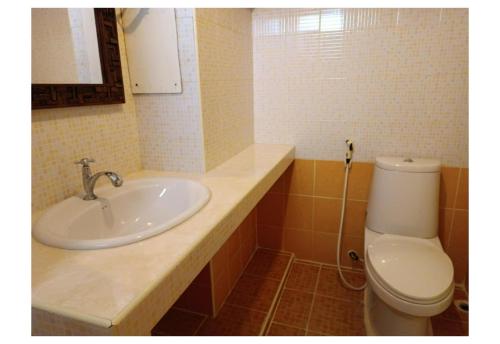 a bathroom with a sink and a toilet at Grandview Condominia in Bangkok