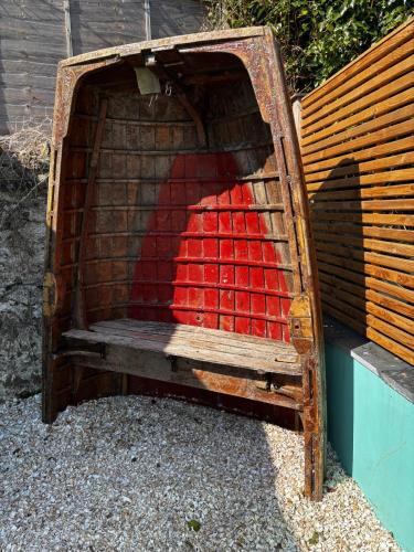 a wooden bench sitting next to a building at Stunning fully refurbished house in New Quay