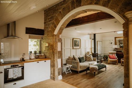 an open kitchen and living room with an archway at Lyme Tree Farm Cottages - Hotching Barn and Knockstone Cottage in Tideswell