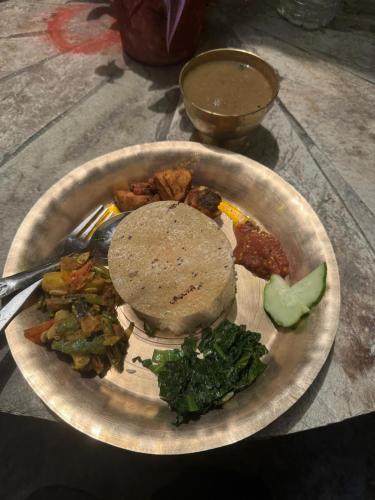 a plate of food with a sandwich and vegetables at Anne Homestay in Pokhara
