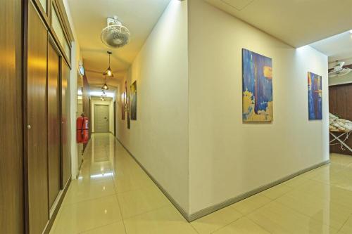 a long hallway with paintings on the walls at Hotel O Fajar Baru Boutique Hotel in Kuala Terengganu