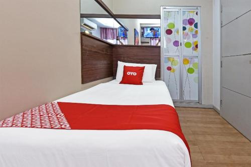 a bedroom with a large bed with a red pillow at Hotel O Fajar Baru Boutique Hotel in Kuala Terengganu