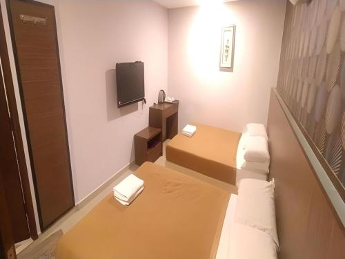 a small room with a bed and a tv at Hotel O Fajar Baru Boutique Hotel in Kuala Terengganu
