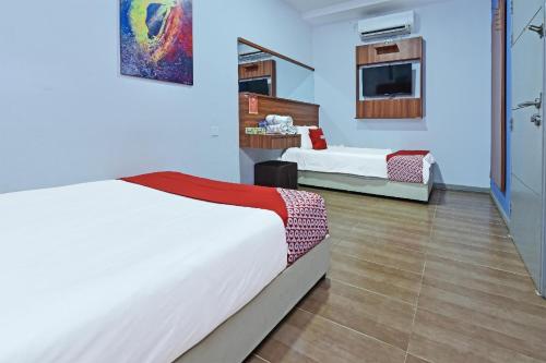 a hotel room with two beds and a tv at Hotel O Fajar Baru Boutique Hotel in Kuala Terengganu
