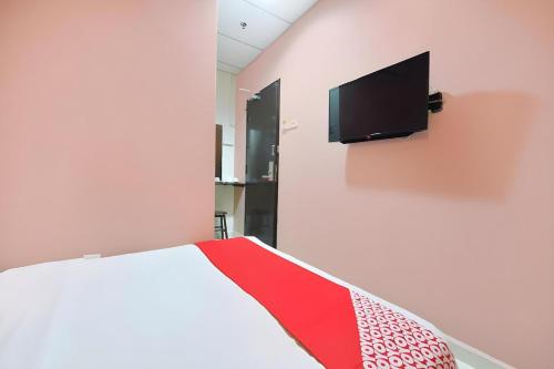 a bedroom with a bed and a tv on a wall at Hotel O Destiny Riverside Hotel in Kota Bharu