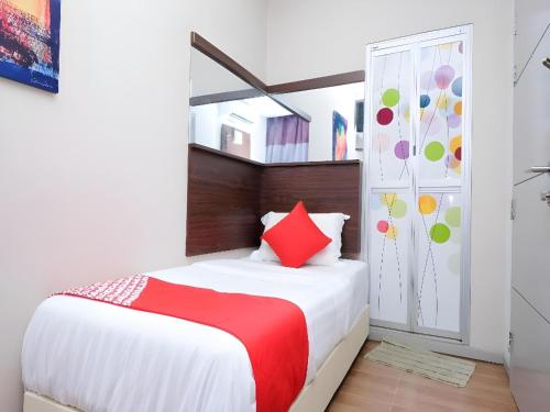 a bedroom with a bed with a red pillow at Hotel O Fajar Baru Boutique Hotel in Kuala Terengganu